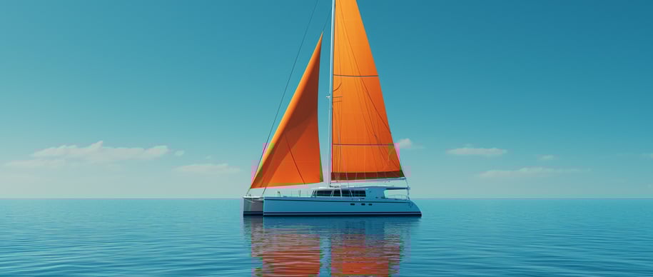 a catamaran in the ocean with a bright orange sailboat