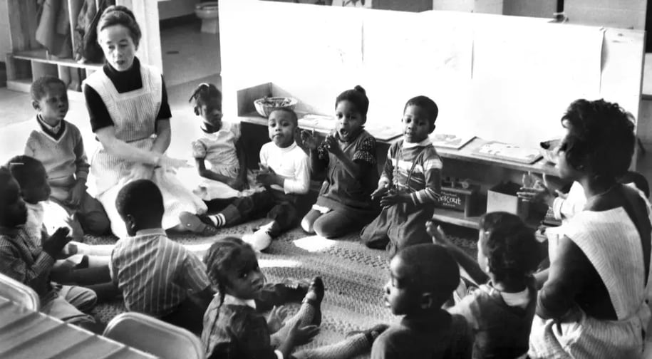 a group of children sitting on the floor in a classroom