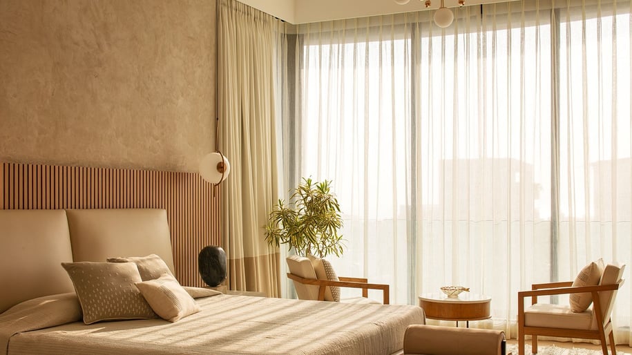 a bedroom with a bed and chairs and a chandelier