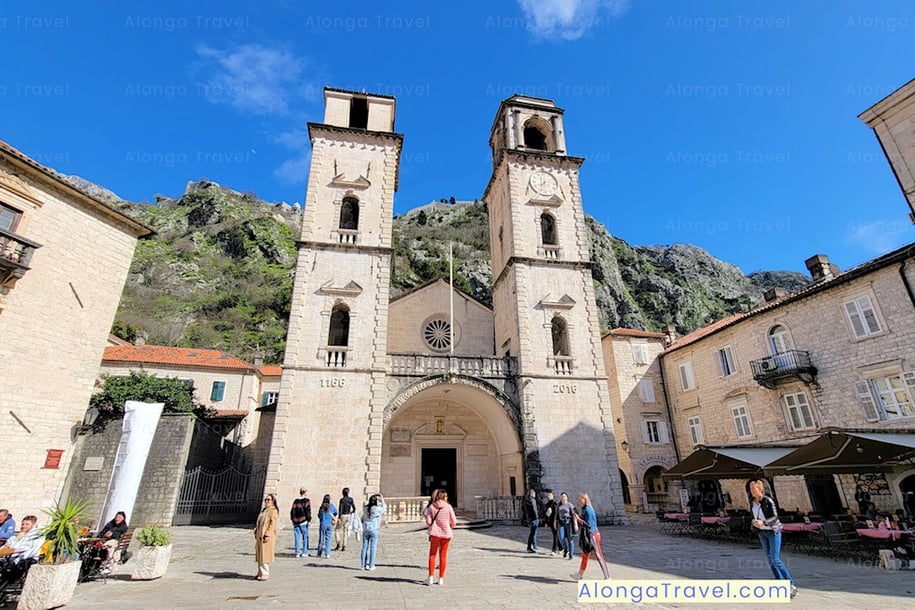 Saint Tryphon's Cathedral against a ⛰ backdrop & a busy square in front of it is one of the must-see