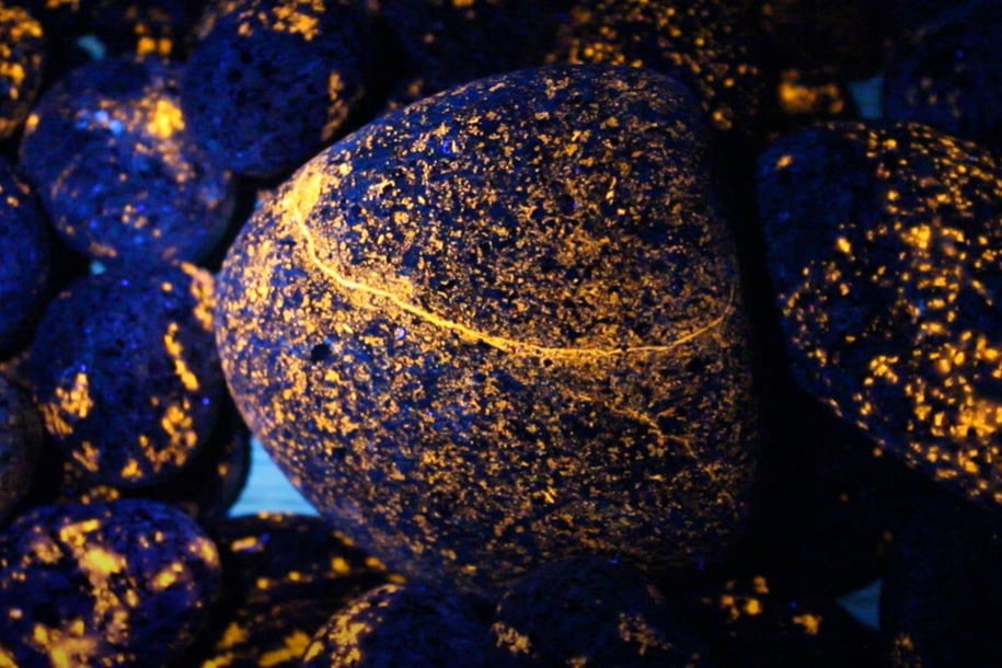 Orange glowing yooperlite rocks under 365nm uv light.