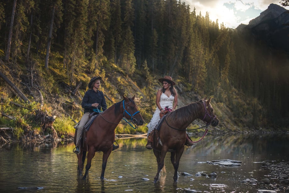 Bride and groom on horses in banff backcountry