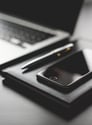 a laptop and a cell phone on a desk