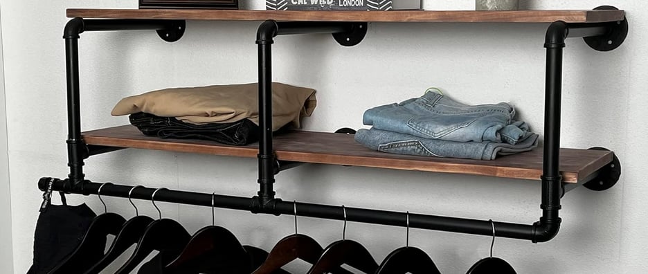 a floating 2-tier shelf on a wall organizing clothes