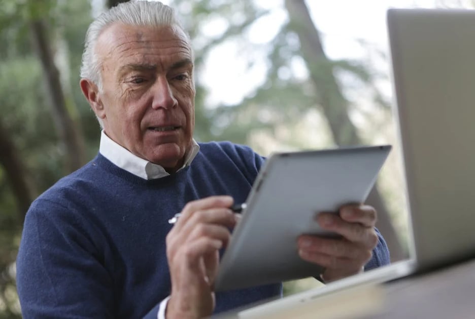 a man in a blue sweater and a laptop