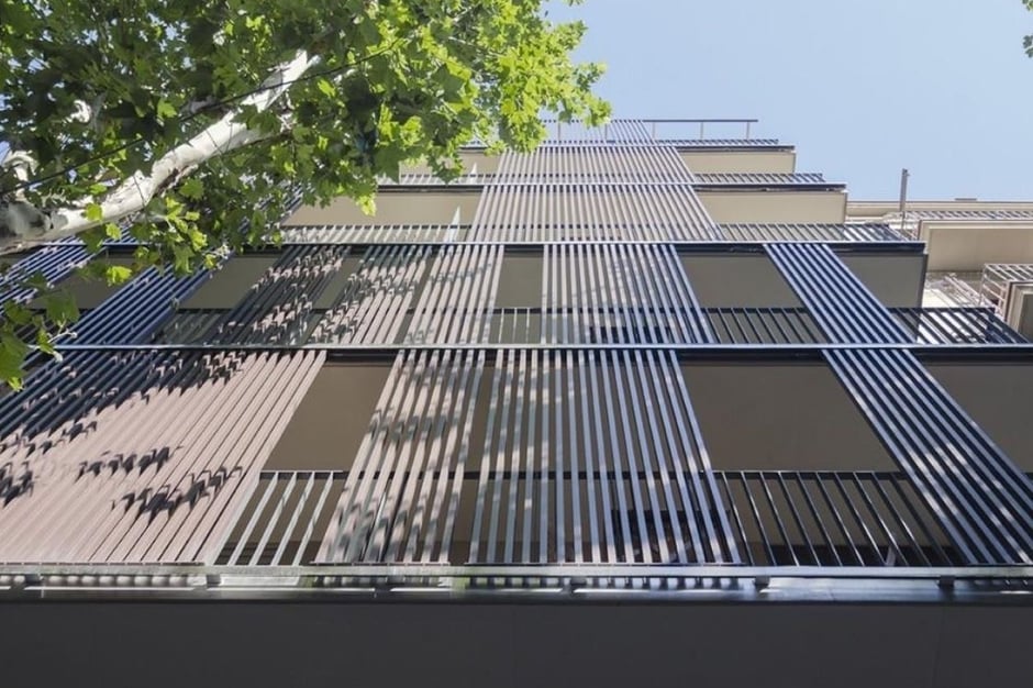 Fachada moderna con lamas verticales de madera y estructura metálica para protección solar y estética arquitectónica