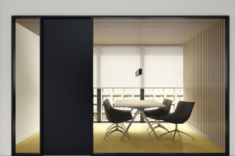 Sala de reuniones moderna con mamparas correderas de cristal y mobiliario minimalista