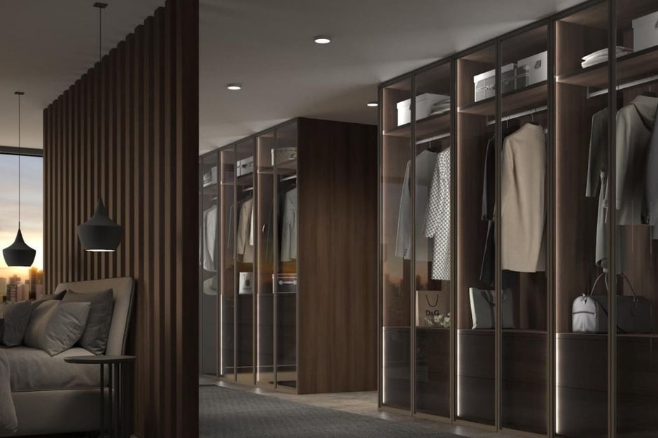 Vestidor elegante con puertas correderas de madera oscura y luz ambiental integrada
