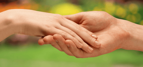 Pareja tomada de la mano frente al amanecer, simbolizando un nuevo comienzo juntos