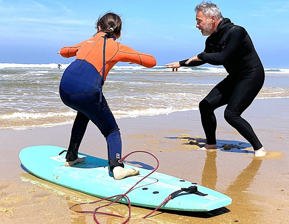 David Marcos, moniteur de surf à Vieux-Boucau, initie une élève au surf sur la plage. 