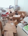 Cluttered sewing room with boxes and paperwork, needing organisation.