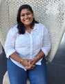 Picture of Elizabeth Jolly sitting in a wicker chair with a white shirt