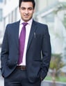 a man in a suit and tie is standing in front of a building