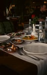 a table with plates of food and glasses