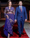 a man and woman in formal attire walking down a red carpet