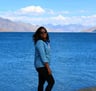 a woman standing on a side of lake