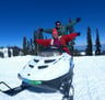 a man and a woman on a snowmobile