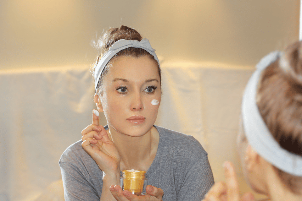 mujer poniendose crema en la cara
