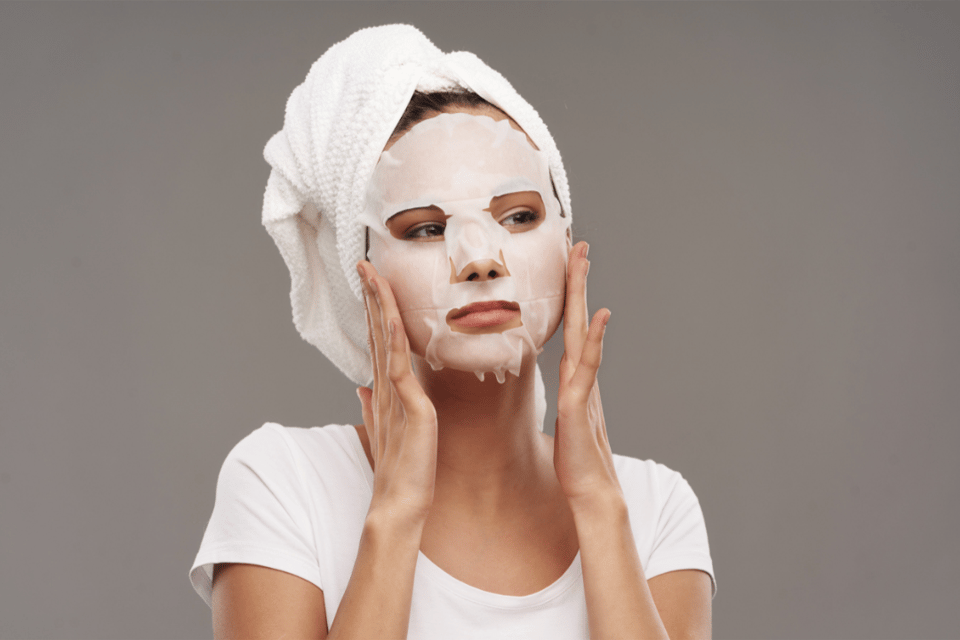 mujer se aplica mascarilla nutritiva en el rostro
