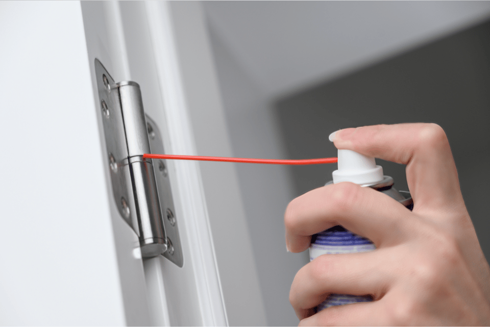 poniendo lubricante a bisagra de puerta