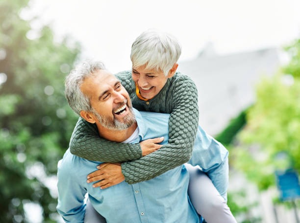 couple souriant de plus de 45 ans la femme est sur le dos de son mari