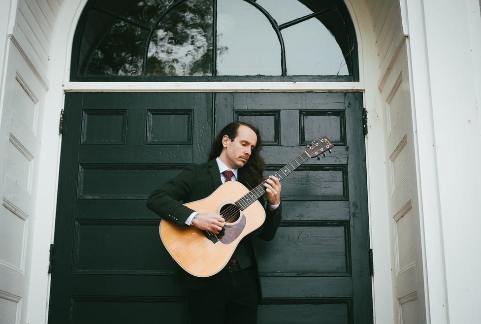 a man in a suit and tie playing guitar