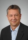 a man in a suit and tie smiling