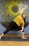 Rachel yoga pose yellow shirt in front of yellow sunflower wall