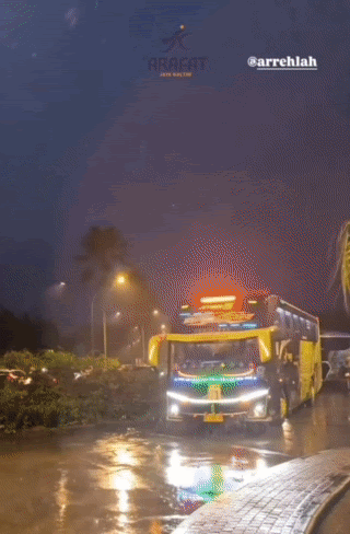 a red and white bus driving down a street