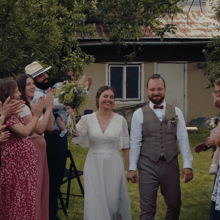 gif of wedding video of couple walking with people applauding