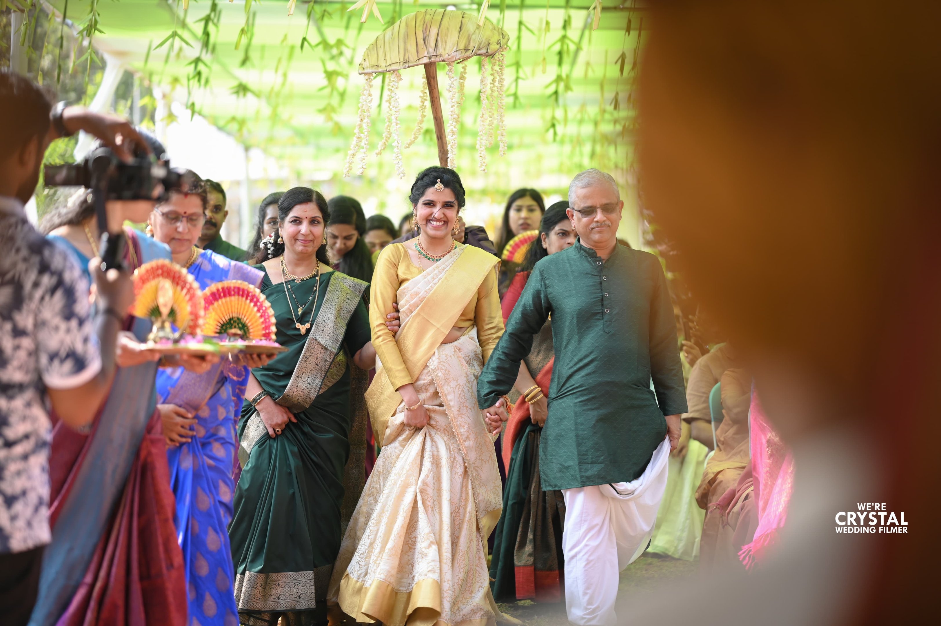 a candid photo during an intimate wedding in kerala, bride enters the stage holding the hand of her father