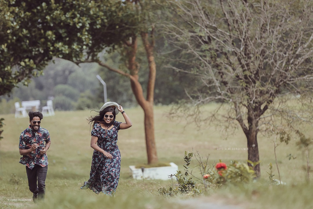 An aerial drone shot of a couple on a Kerala beach for their epic save the date.