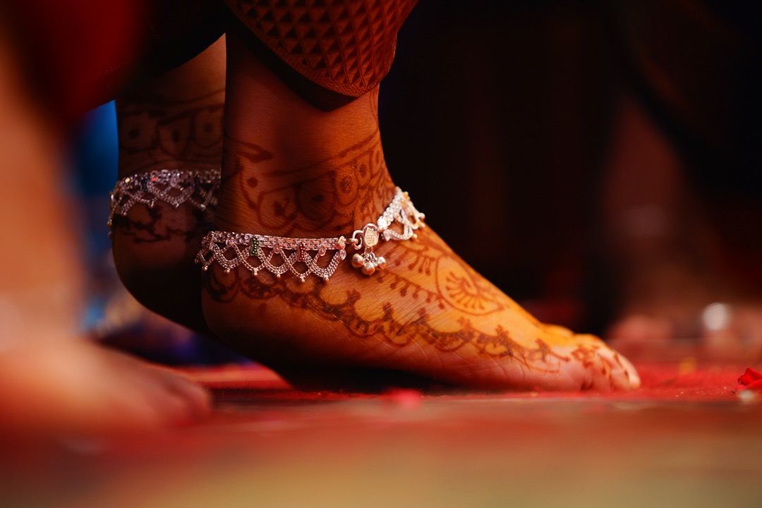 mehandi on her feet with a silver anklet bride on her Palakkad wedding photography session