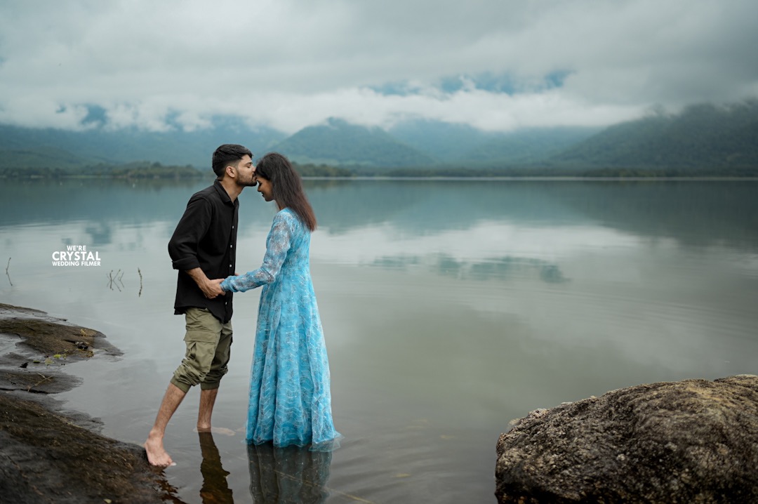 A candid moment from a pre-wedding photography session in Kerala, with the groom whispering to the bride.