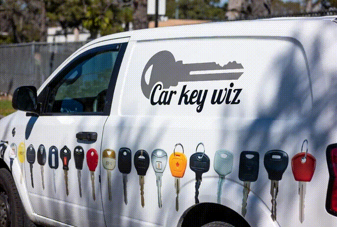 Car Key Wiz van with keys on it is parked in front of a fence
