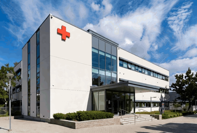 a large white building with a red cross on the front