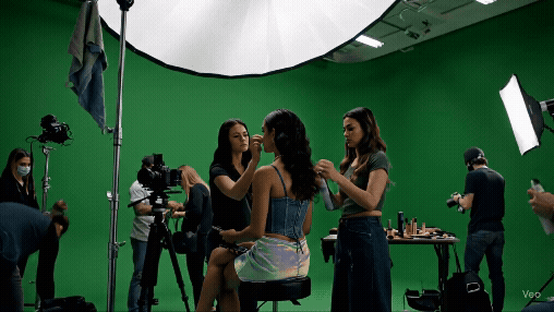 a woman in a dress is taking a photo of a green screen