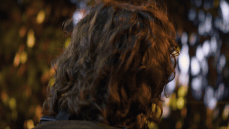 a woman with long hair and glasses on her phone and a man holding binocular