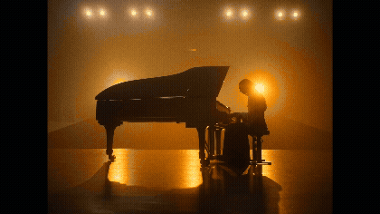 a person sitting at a piano in front of a piano