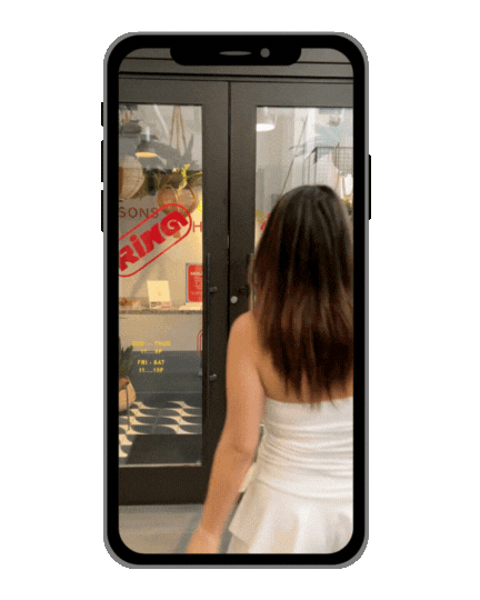 a woman in a white dress is looking at a phone